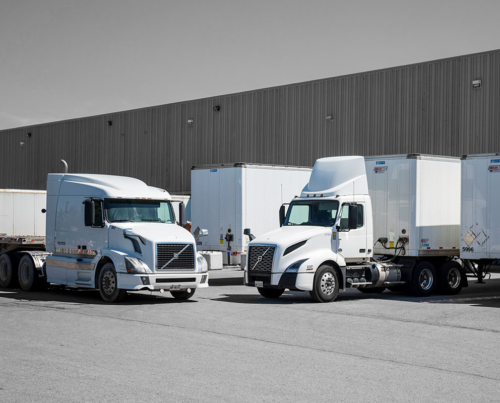 Third party logistics trucks and trailers parked outside of Bowden Transport warehouse